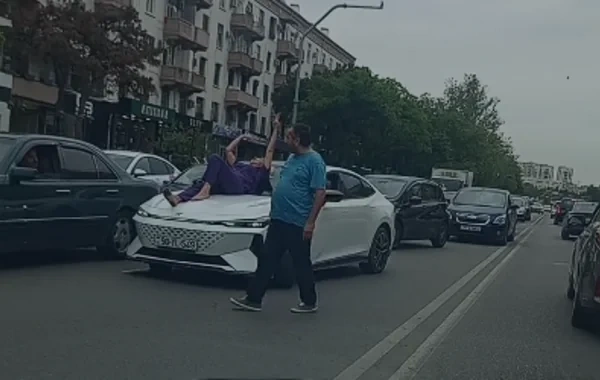 Bakıda qəribə hadisə: Qadın küçədə avtomobilin üzərinə uzandı, hərəkət iflic oldu - VİDEO